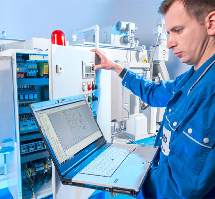 Ein Servicemonteur steht an einer Filteranlage. Er hält seinen Laptop in der Hand. Der Laptop ist mit dem Schaltkasten verbunden